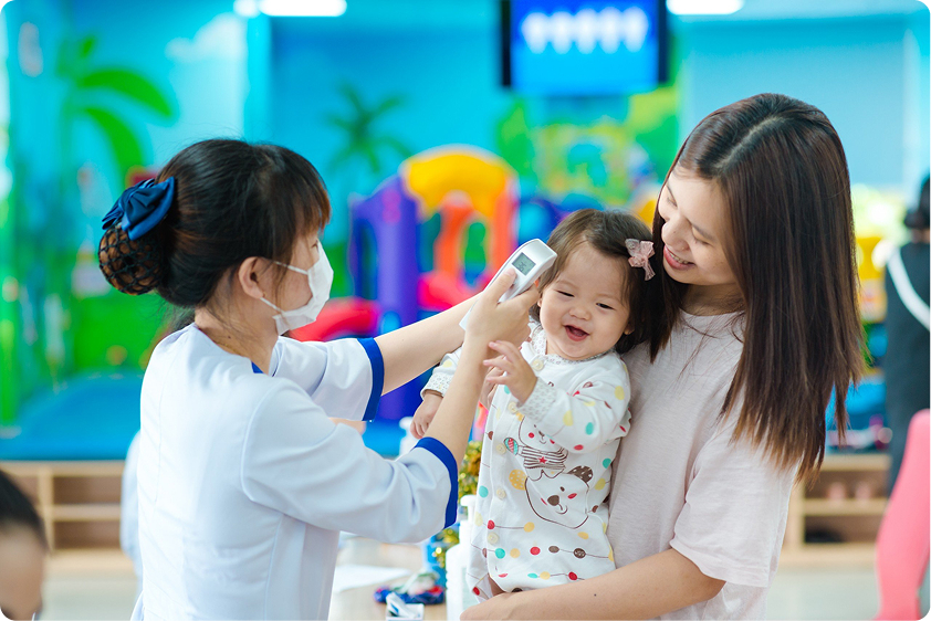 nhân viên đo nhiệt độ cho bé